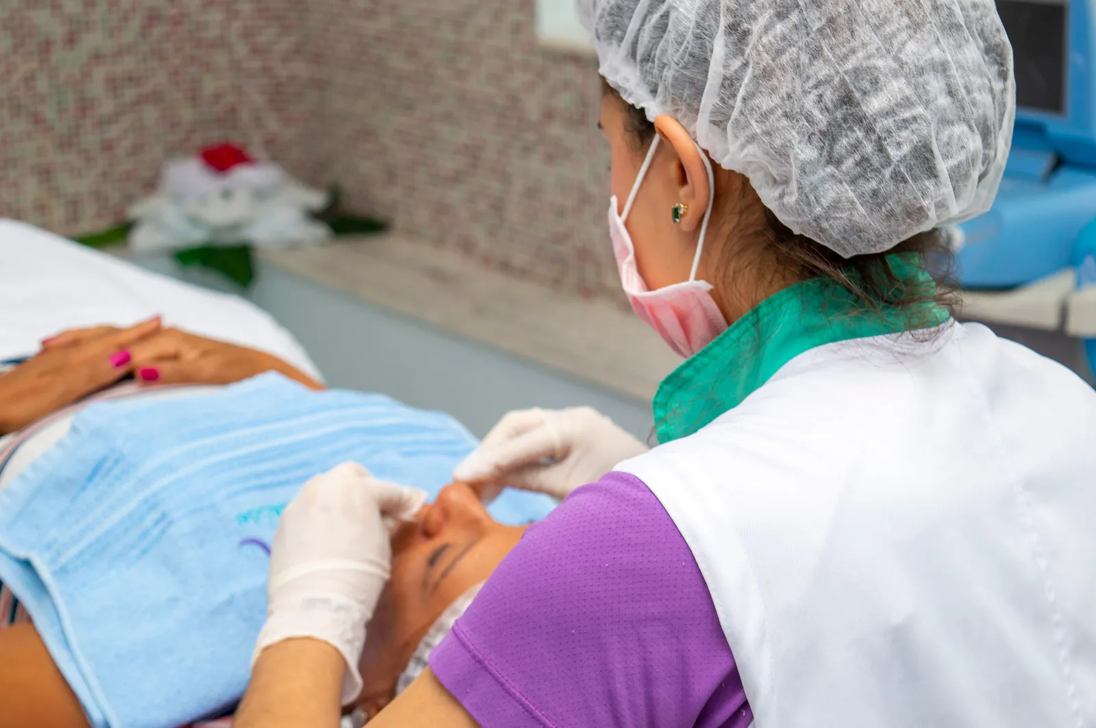 Esteticista fazendo limpeza de pele no rosto de uma cliente na Ergon, em Sorocaba