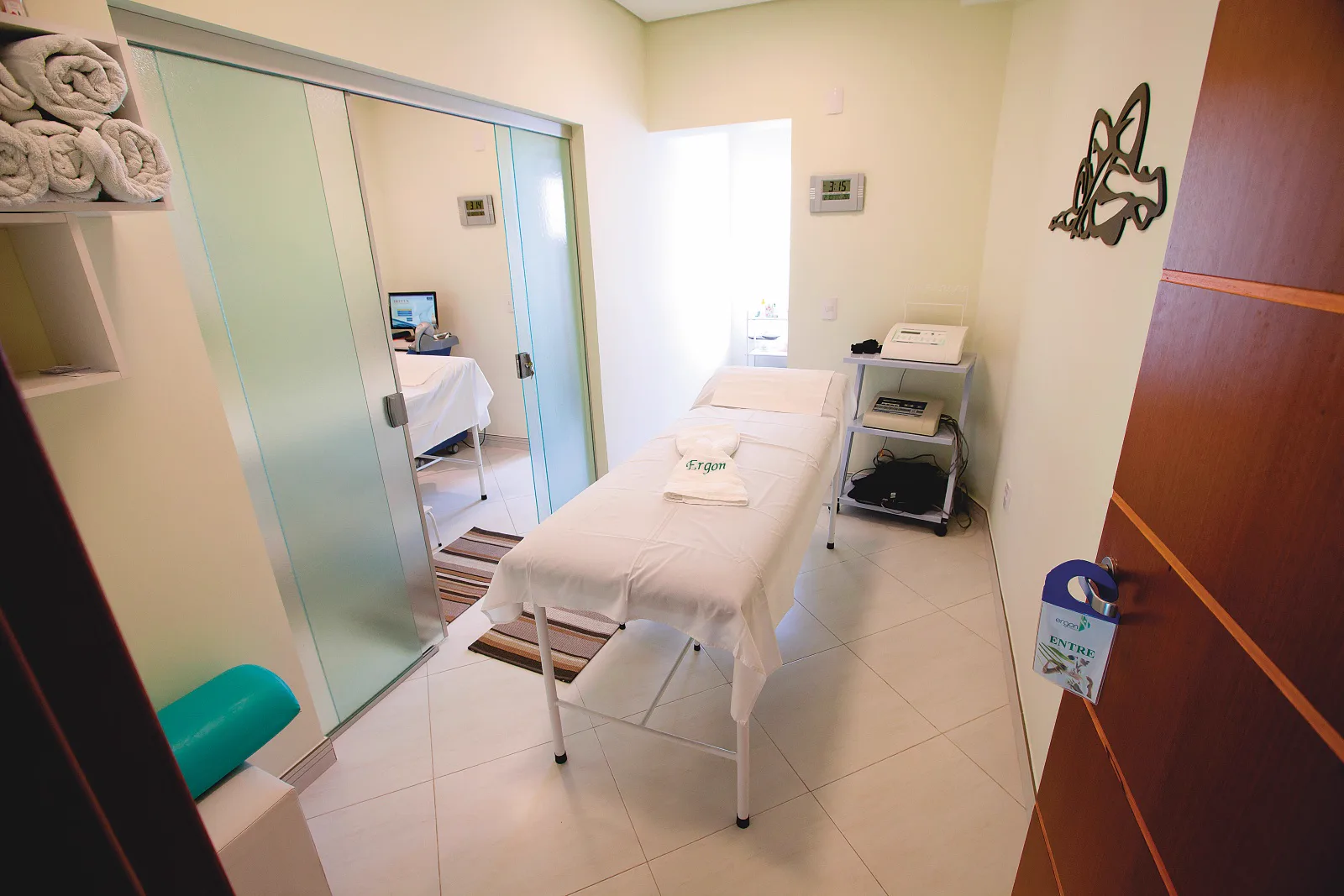 Sala de estética corporal com maca e espelho na Ergon Saúde, em Sorocaba