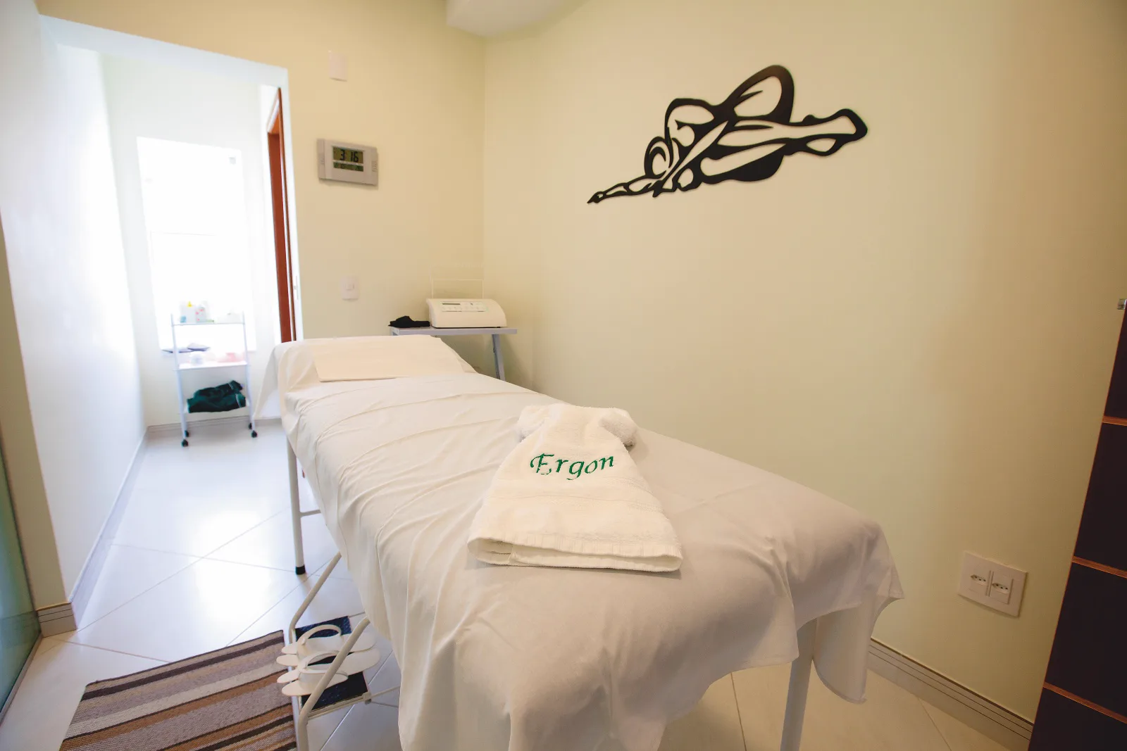 Sala de massagem da Ergon Saúde em Sorocaba com maca e toalha bordada, onde é feita a massagem lipolítica