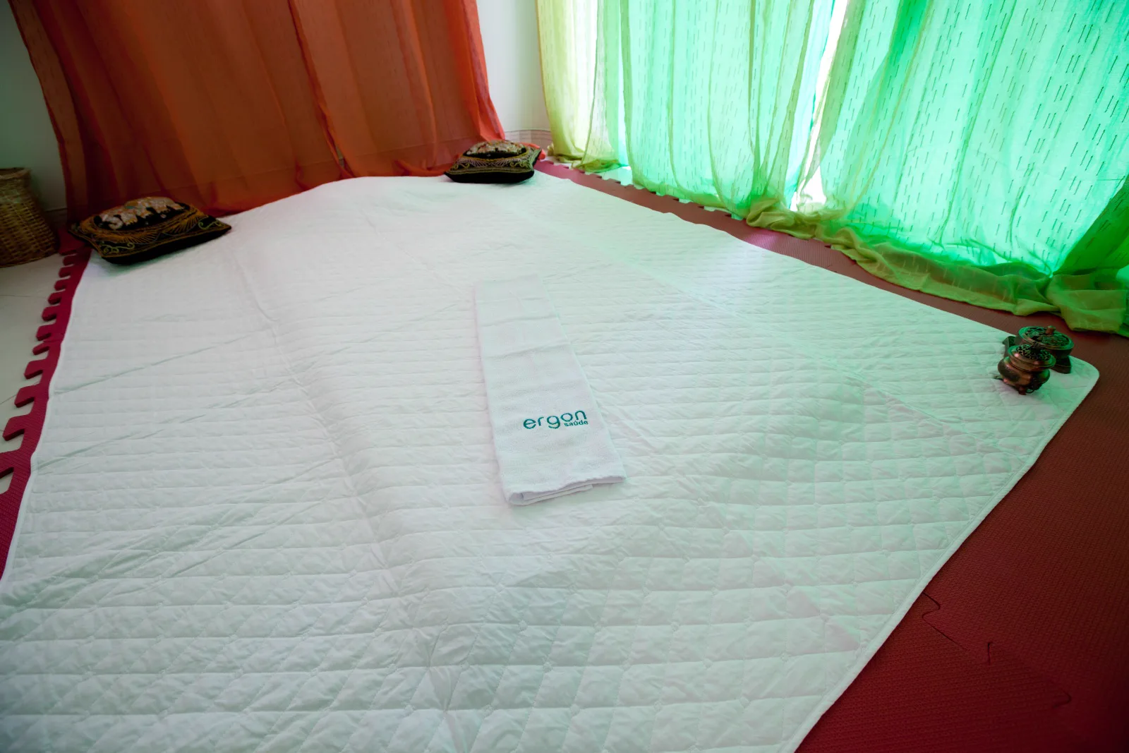 Sala de tatame com toalha Ergon e cortinas coloridas, onde é feita a ayurvedaterapia em Sorocaba
