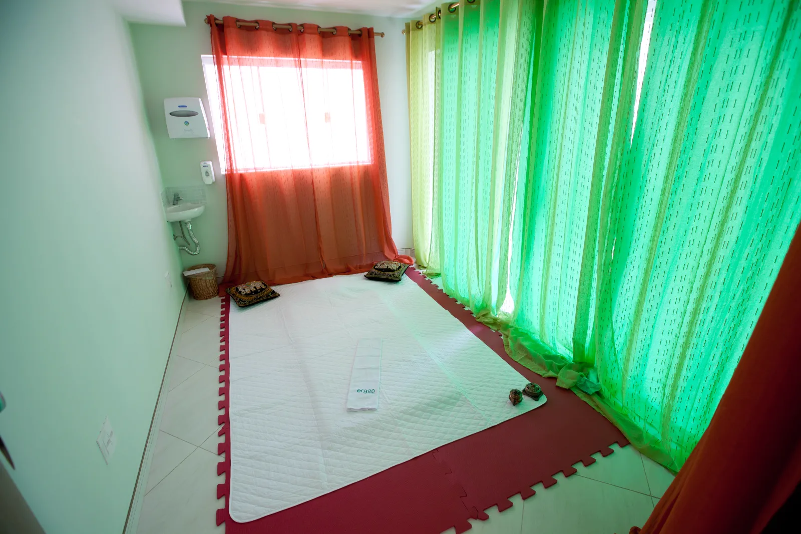 Sala de tatame com cortinas coloridas na Ergon Saúde, em Sorocaba, onde é feita a massagem indiana