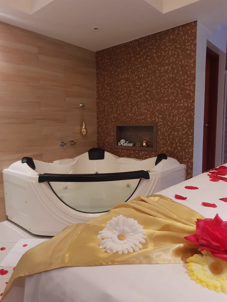 Banheira de hidromassagem da Ergon com pétalas e flores para ritual de spa